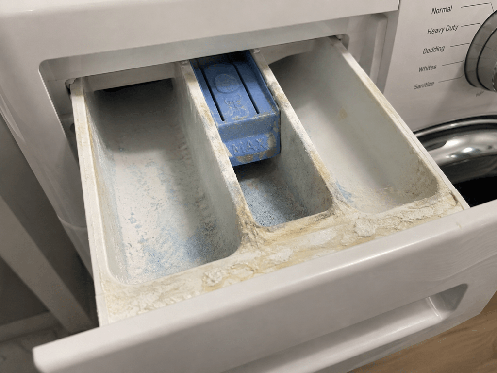 Front-load washer detergent drawer with detergent and mineral residue